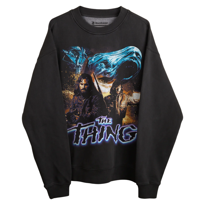 Black long-sleeved sweatshirt with ’the thing’ graphic design featuring two characters and a blue wave-like element.
