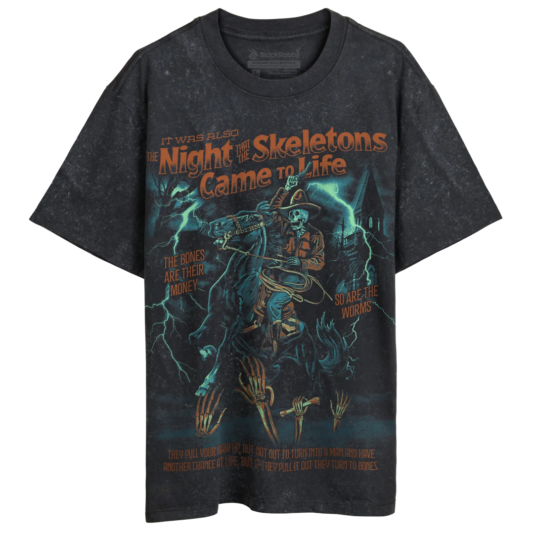 A black, distressed t-shirt with a graphic print featuring a skeleton cowboy on horseback, lightning, and a haunted house.