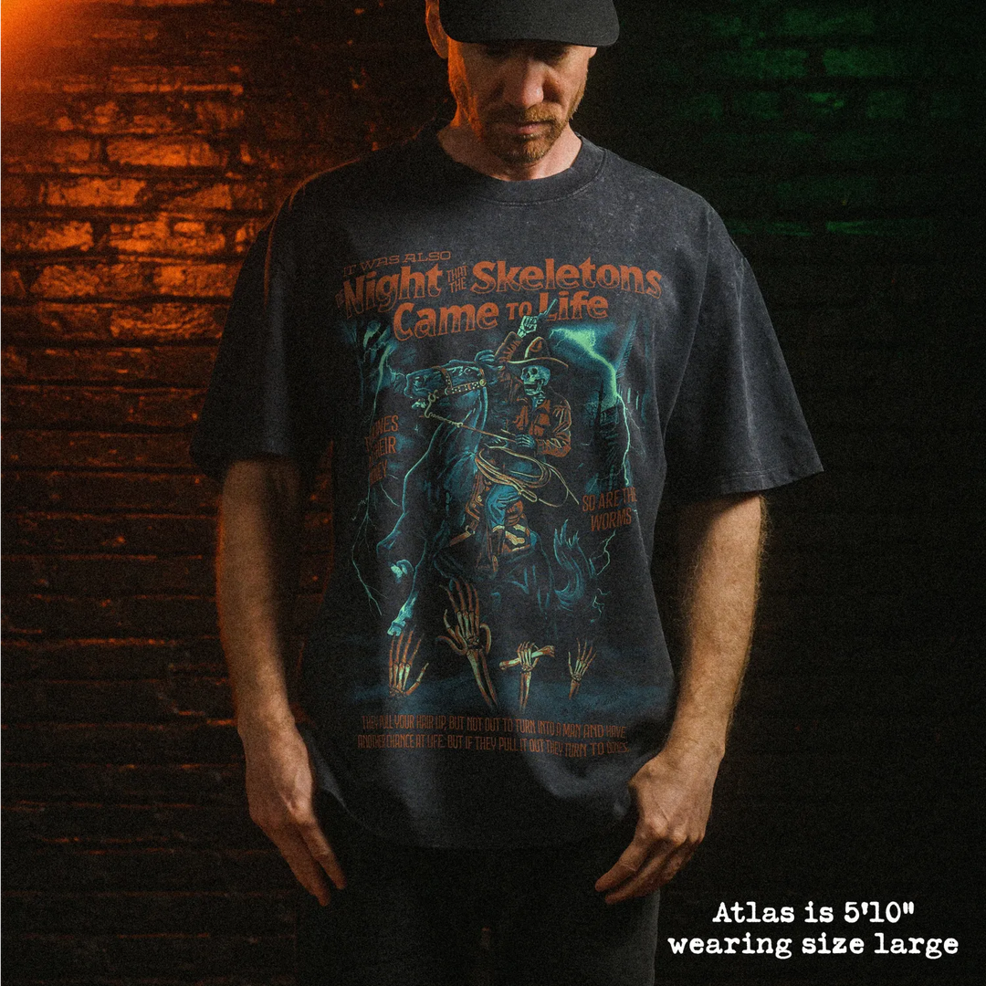 Male model wearing heavy stone washed tee with skeleton song graphic. 