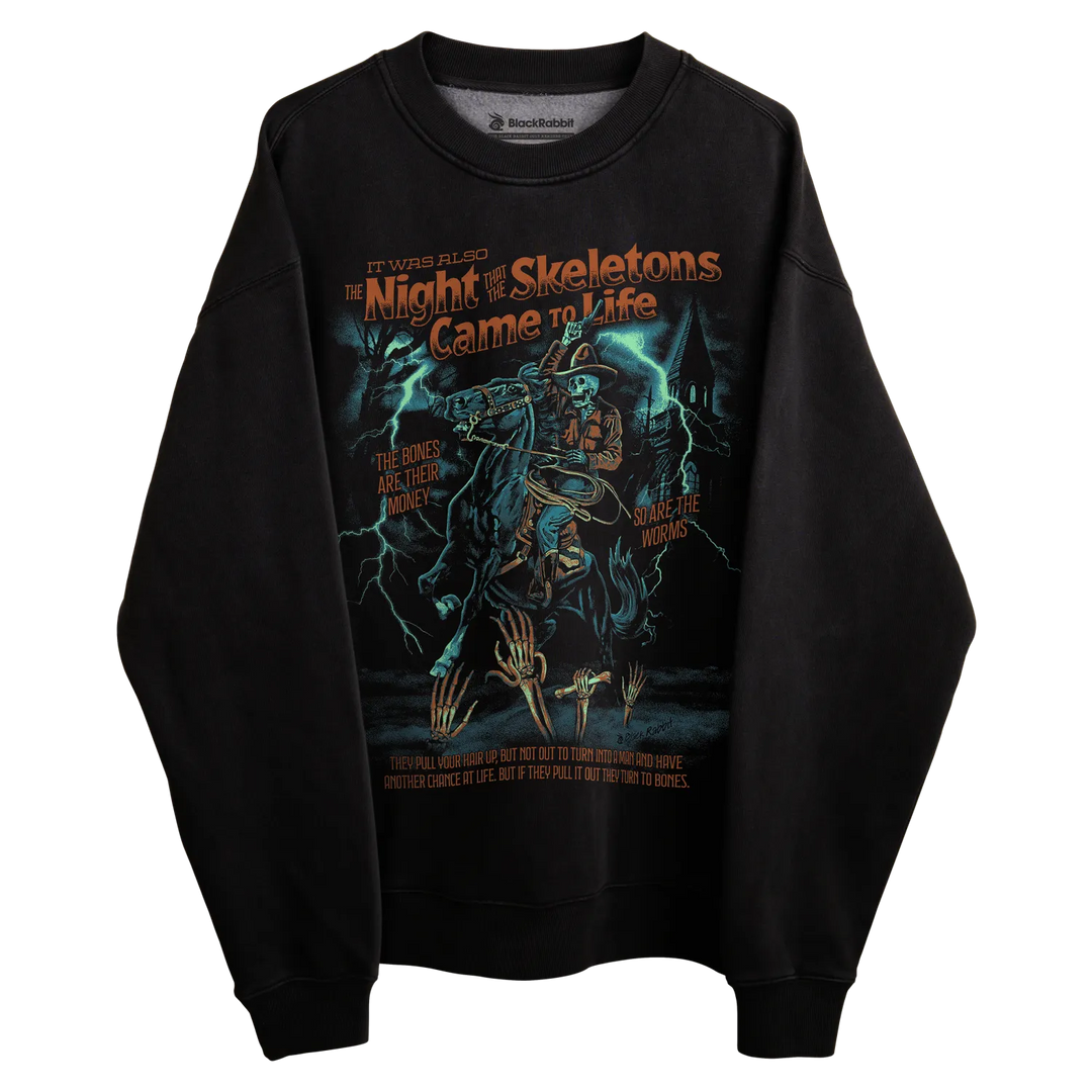 Black long-sleeved sweatshirt with ’the night the skeletons came to life’ graphic design featuring a skeleton and lightning bolts.