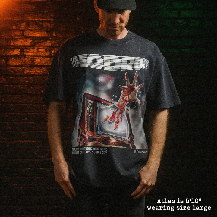 Male model wearing heavy stone washed tee with videodrome graphic. 