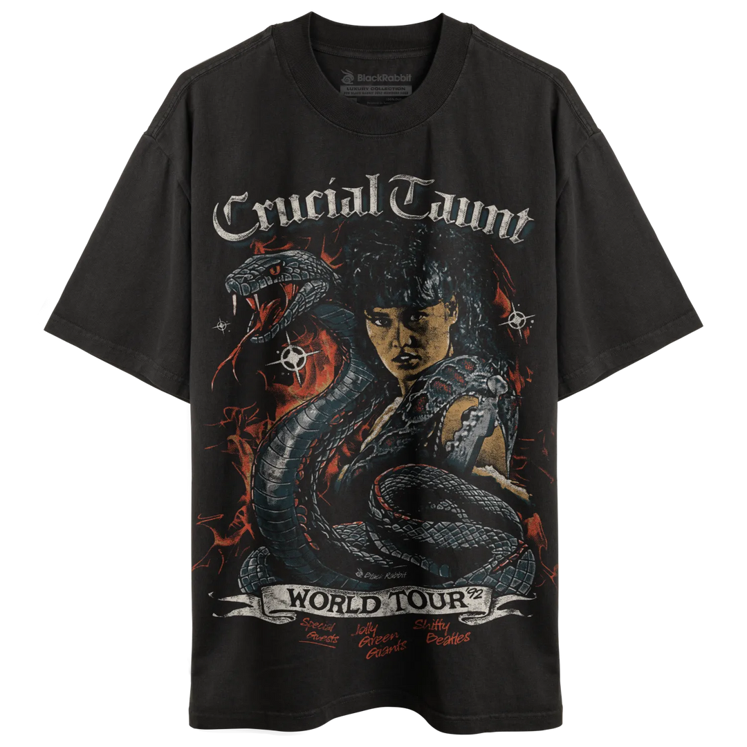 Dark grey oversized t-shirt with a graphic print featuring a woman, a snake, and ’Crucial Taunt World Tour’ text.