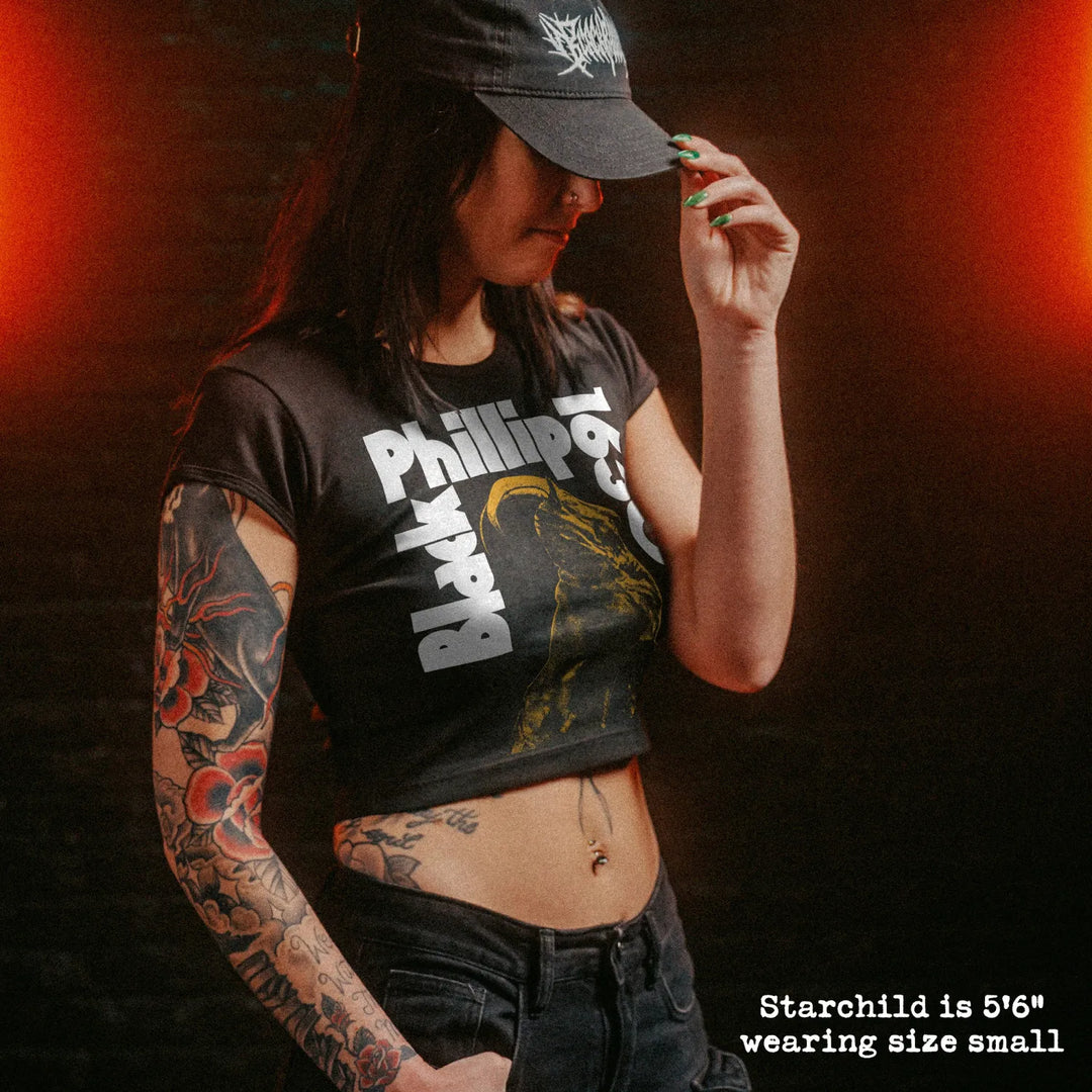 Female model wearing cropped baby tee with black phillip graphic
